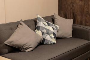 a gray couch with four pillows on it at 102 Centro 2Bdrm 2bath apt AC Rooftop in Mexico City