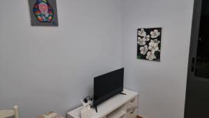 a flat screen tv sitting on top of a white cabinet at Luxury Two Bedrooms and two balcony beachfront apartment in Vlorë