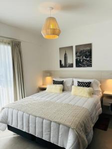 a bedroom with a large white bed with two pillows at Studio Ezeiza Aeropuerto 204 in Ezeiza