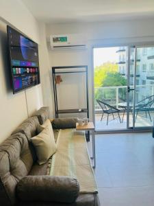 a living room with a couch and a balcony at Studio Ezeiza Aeropuerto 204 in Ezeiza