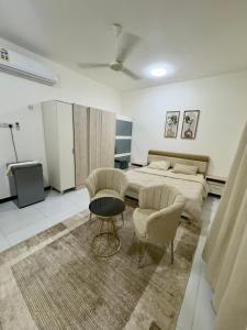 a bedroom with a bed and a table and chairs at رخاء للغرف الفندقية in Firq