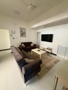 a living room with a couch and a tv at رخاء للغرف الفندقية in Firq