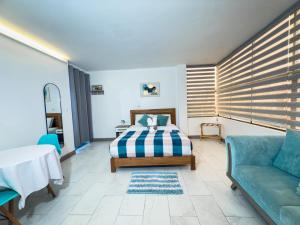 a bedroom with a bed and a couch and a table at Libertad 109 Hotel in La Libertad