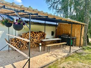 a pergola with a table and a pile of logs at Dolpo 55 - Pouze pro dospělé in Benešov