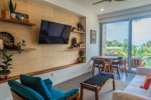 a living room with a tv on a brick wall at Sunset Boulevard 304 in Pochotal