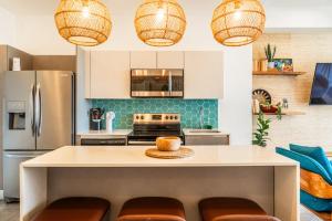 a kitchen with a large island with brown chairs at Sunset Boulevard 304 in Pochotal