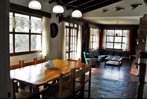 a dining room with a wooden table and a living room at Cuatro Cerros in San Carlos de Bariloche