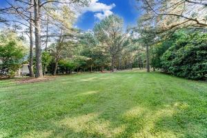 un vaste champ d'herbe planté d'arbres en arrière-plan dans l'établissement Charlotte Area Getaway Retreat & Event Venue Weddings & More in Mint Hill, à Charlotte