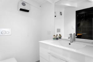 a white bathroom with a sink and a mirror at The Wee Glen - Peaceful Country Retreat 2 bed in Bennetts