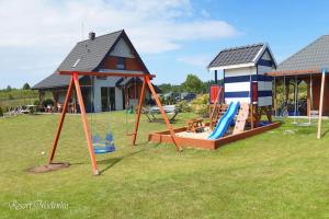 une aire de jeux dans une cour avec une maison dans l'établissement Holiday home with garden, sauna, jacuzzi, à Mielenko