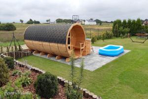 un grand bateau en bois assis dans une cour dans l'établissement Holiday home with garden, sauna, jacuzzi, à Mielenko