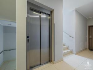a glass elevator in a hallway with stairs at Apartment in Pobierowo near Baltic Beach in Pobierowo