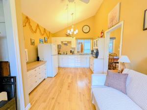 a living room with a couch and a kitchen at Waterfront Comfy Guesthouse, PEC in Carrying Place