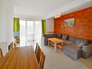 a living room with a couch and a table at Holiday home with garden, close to the beach in Sarbinowo