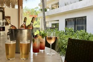 una mesa con botellas de vino y copas. en Casa Leah Puerto Escondido, en Puerto Escondido