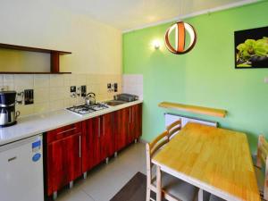 a kitchen with a table and a kitchen with green walls at Holiday home with garden, close to the beach in Sarbinowo