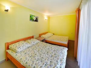 two beds in a room with yellow walls at Holiday home with garden, close to the beach in Sarbinowo