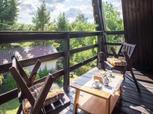 a porch with two chairs and a table with teaitures at Holiday Home near Lake Radunskie with Sauna in Przewóz
