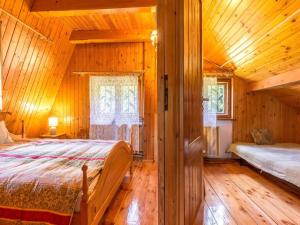 a bedroom with a bed in a wooden cabin at Holiday Home near Lake Radunskie with Sauna in Przewóz
