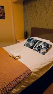 a bed with blue and white pillows on it at Traditional Kingston Flat With Garden-2 Bed in Kingston upon Thames +15 photos