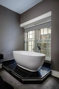 a large white bowl on a black counter in a bathroom at Luxury royal mile boutique 2bedroom apartment in Edinburgh