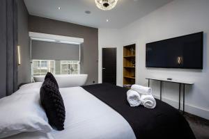 a bedroom with a large white bed with a flat screen tv at Luxury royal mile boutique 2bedroom apartment in Edinburgh
