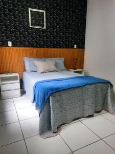 a bedroom with a bed with a blue comforter at Casa cop 30,a 1min do aeroporto e 5 do parque da cidade in Belém