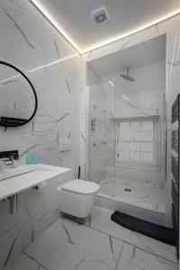 a white bathroom with a shower and a toilet at Luxury royal mile boutique 2bedroom apartment in Edinburgh +5 photos