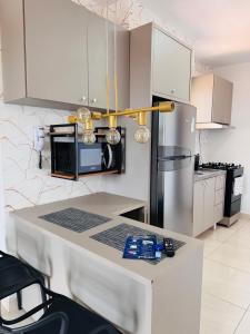 una cucina con mobili bianchi e un piano di lavoro di Apê ideal para Você, com Academia e Piscina a Cuiabá