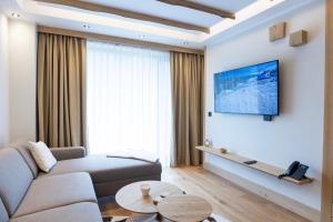 a living room with a couch and a tv on a wall at BiancaNeve Jahorina in Jahorina +31 photos