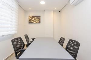 a meeting room with a white table and chairs at Eco Smart - Ecoville | Gonzaga Stays in Curitiba