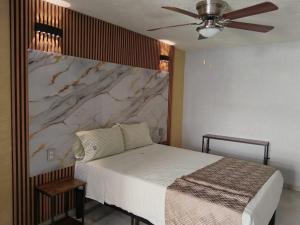 a bedroom with a bed with a marble wall at HOTEL SOL in Guadalajara