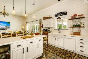 een keuken met witte kasten en een spoelbak bij DreamBoat Paradise Heated Pool- Hot Tub near Beach in Pensacola