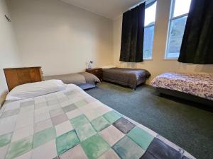 Cette chambre comprend deux lits, un canapé et des fenêtres. dans l'établissement Friends & Family Groups gather, à Roxburgh