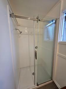 une douche avec une porte vitrée dans une salle de bain dans l'établissement Friends & Family Groups gather, à Roxburgh 21 autres photos