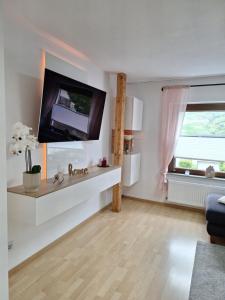 ベルンカステル・クースにあるFeriennest Zitaの壁に薄型テレビが取り付けられたリビングルーム