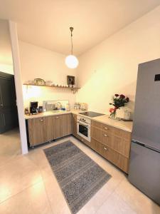 a kitchen with wooden cabinets and a stainless steel refrigerator at Nocleg w Olecku Parkowa in Olecko