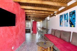 sala de estar con pared roja y sofá rojo en Villa Casa Blanca, en Chiclana de la Frontera