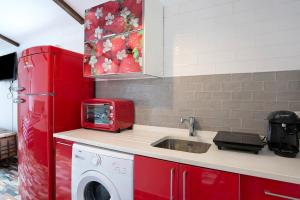 a kitchen with a sink and a red refrigerator at Villa Bali in Chiclana de la Frontera
