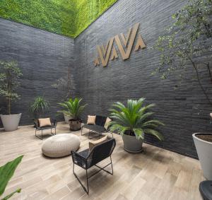 a lobby with chairs and a sign on a brick wall at Felix by Viadora in Mexico City +1 photo