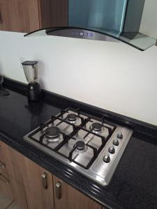 un four avec plaques de cuisson installé au-dessus d'un comptoir de cuisine dans l'établissement Apartamento con picina en zona hotelera, à Puerto Vallarta