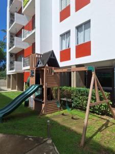 une aire de jeux devant un bâtiment avec un toboggan dans l'établissement Apartamento con picina en zona hotelera, à Puerto Vallarta