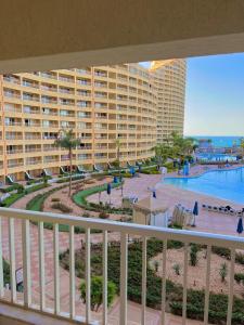a balcony with a view of a pool and a resort at Amer Group Sokhna - عطلة أحلامك in Ain Sokhna