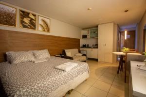 a bedroom with a bed and a living room and a kitchen at Suíte luxo com tela de cinema no América Towers Studio Residence in Salvador