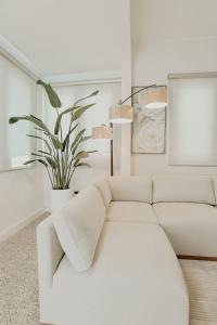 a white couch in a living room with a plant at Elegant Home with KingBed Private Patio Ensuites in San Juan