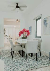 a white dining room with a table and chairs at Elegant Home with KingBed Private Patio Ensuites in San Juan
