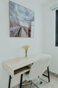 a wooden table with a white chair and a picture on the wall at Elegant Home with KingBed Private Patio Ensuites in San Juan