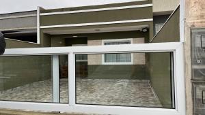 a building with a large glass window in front of it at Casa Piscina Guaratuba 400mt praia in Guaratuba