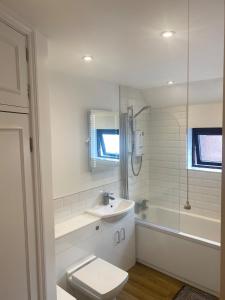 a bathroom with a toilet and a sink and a tub at Modern 1 bedroom flat in useful location in Yeovil