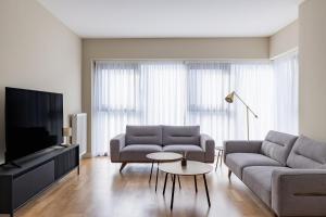 ein Wohnzimmer mit Sofa und Fernseher in der Unterkunft Limak's Diamond Residences in Skopje